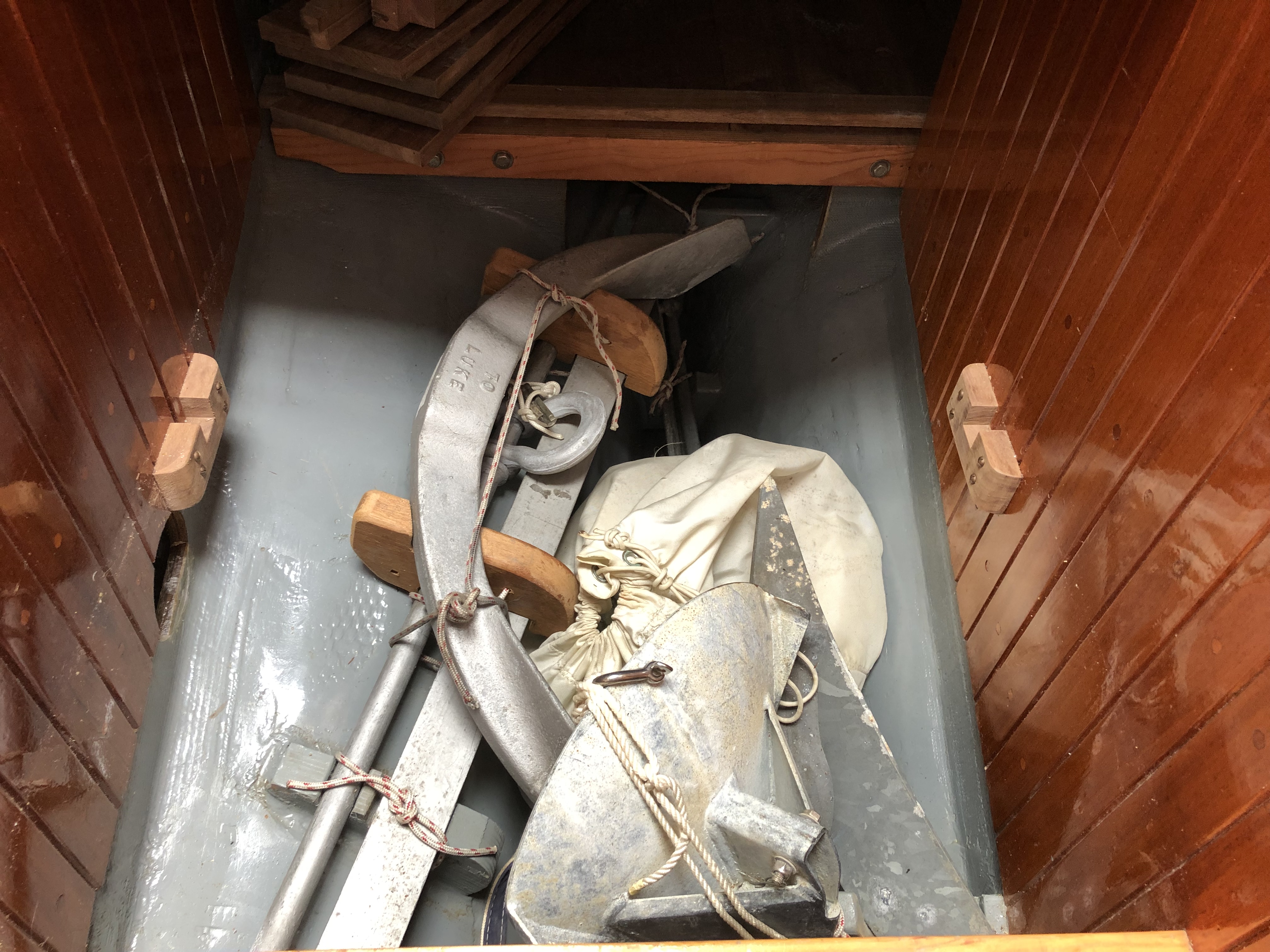 The purpose built anchor storage locker under the companionway ladder. In addition to 140lbs of spare and back up anchors is another 230 lbs in lead pigs to compensate for the original Perkins 4-107.